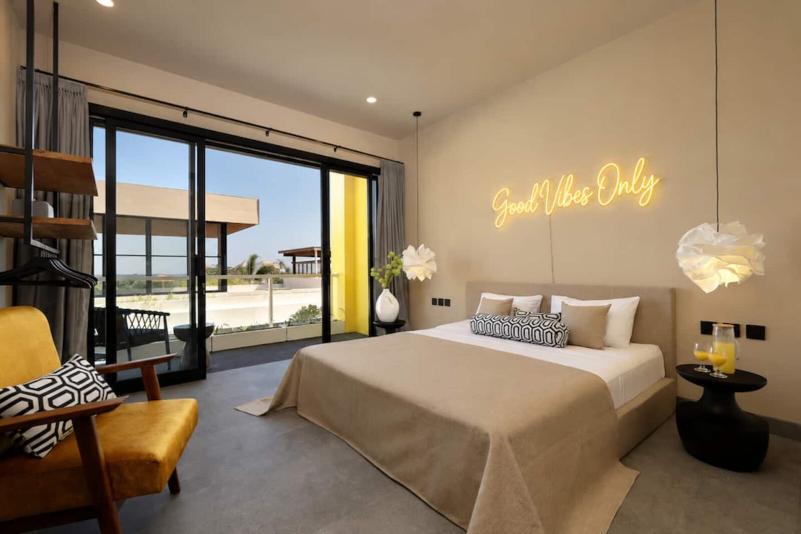 Bedroom opening onto a terrace with an ocean horizon behind the balustrade