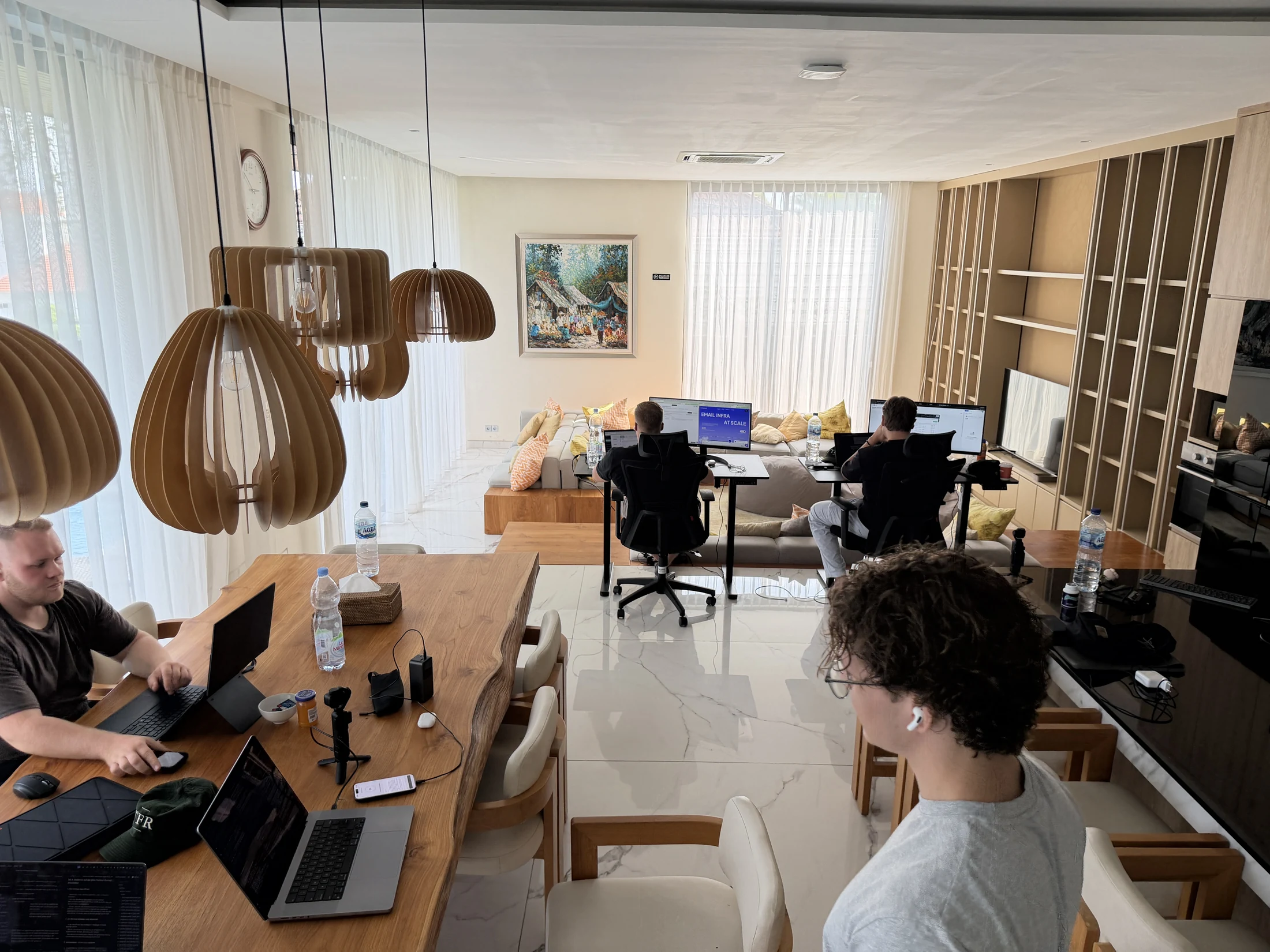 Mehrere Teilnehmer arbeiten gemeinsam im hellen Wohn- und Arbeitsbereich der Villa auf Bali