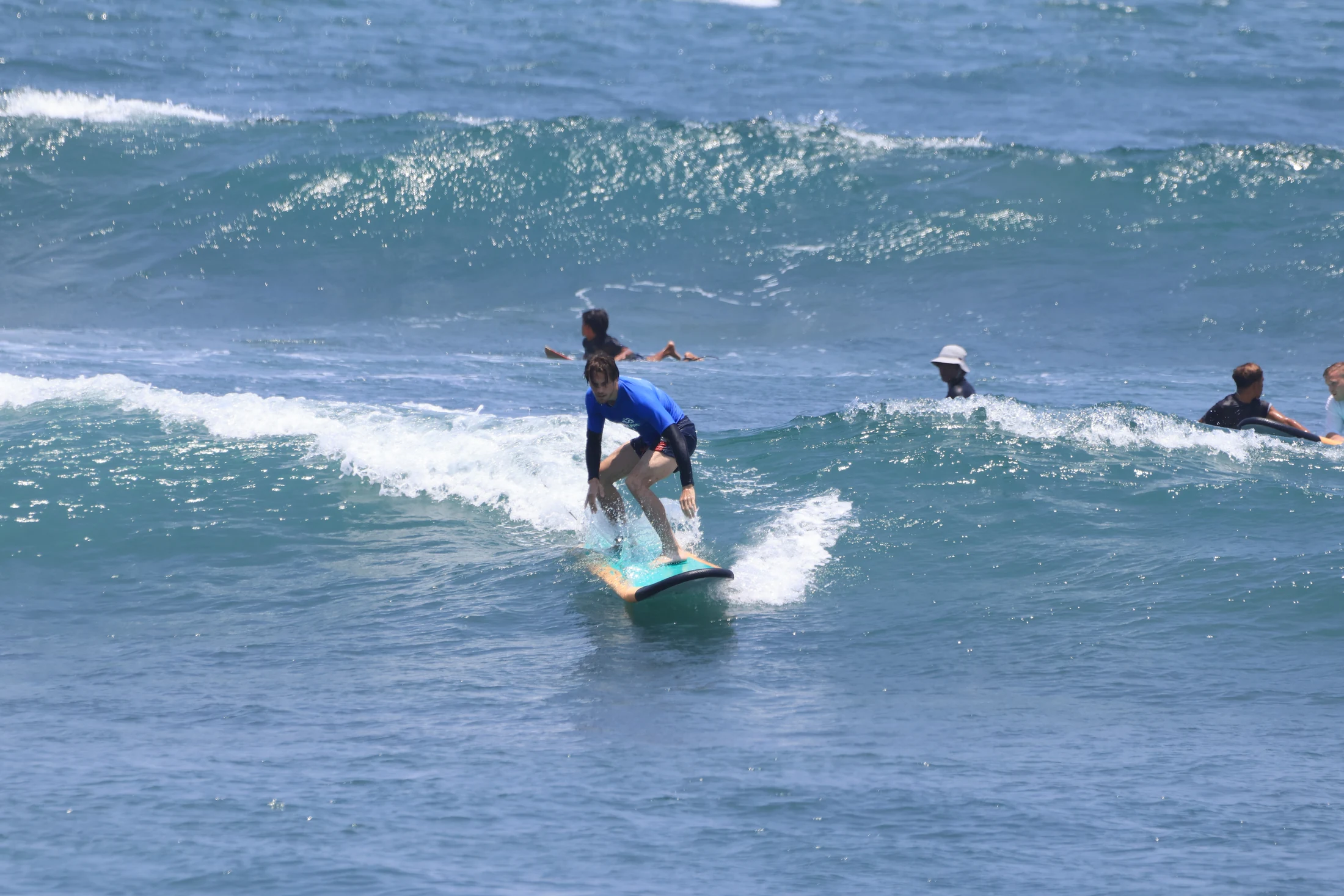 Ein Teilnehmer surft im blauen Meer vor Bali